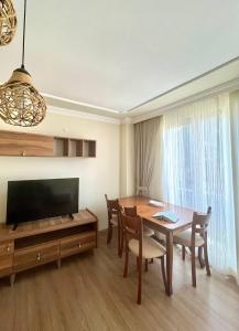 a living room with a dining room table and a television at Halic Apart Hotel in Yalova