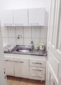 een kleine keuken met een wastafel en een aanrecht bij Apartamento Suíte encantador in Gramado