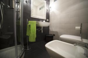 a bathroom with a sink and a toilet and a mirror at I Balconi sul Barocco in Modica