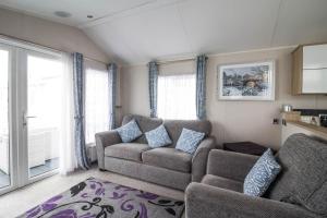a living room with a couch and a chair at Luxury Caravan At Seaview Holiday Park In Kent Ref 47034pb in Whitstable