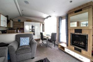 a living room with a couch and a television and a table at Luxury Caravan At Seaview Holiday Park In Kent Ref 47034pb in Whitstable