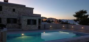 a swimming pool in front of a house at Apartments-Sana-2 in Vir +6 photos