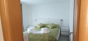 a bed in a white room with towels on it at Apartments-Sana-2 in Vir