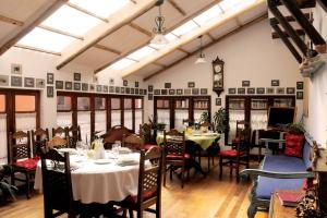 a dining room with tables and chairs and a clock at Hotel Museo Cayara in Santa Lucía