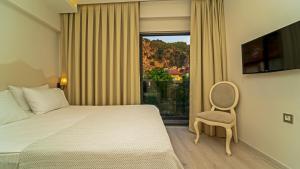a bedroom with a bed and a chair and a window at Rooms365 in Fethiye