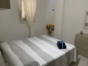 Un dormitorio con una cama con una bolsa azul. en La Conchiglia, en Torre Ovo