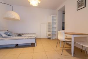 um quarto com uma cama, uma mesa e cadeiras em Urban Nest Apartments Radziwiłłowska 12 em Cracóvia