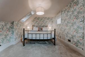 a bedroom with a bed in a room with floral wallpaper at The Old Choir School in uphill Lincoln in Lincolnshire