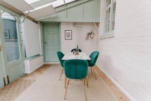 a room with a table and green chairs on a porch at The Old Choir School in uphill Lincoln in Lincolnshire