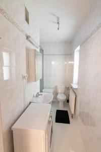 uma casa de banho branca com um lavatório e um WC em Urban Nest Apartments Radziwiłłowska 12 em Cracóvia