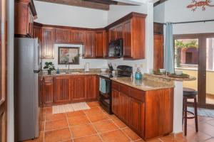 a kitchen with wooden cabinets and a refrigerator at Gecko Getaway condo in Roatán