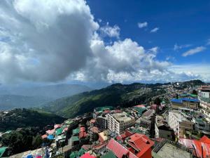 vistas a una ciudad con edificios y montañas en Primrose Apartment, en Darjeeling