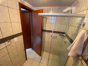 La salle de bains est pourvue d'une douche et d'une porte en verre. dans l'établissement Apto 2 dormitórios em Balneário Camboriú, à Balneário Camboriú