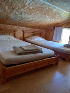 two beds in a room with a wooden ceiling at Casa di legnu ,charmant chalet avec piscine in Patrimonio