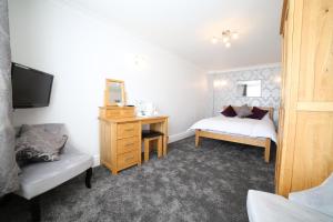 a bedroom with a desk and a bed and a mirror at Dalegarth Guesthouse Portinscale in Keswick