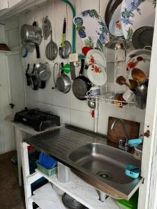 a kitchen with a sink and lots of pots and pans at Flor de la selva in Puerto Nariño