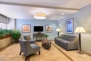 a living room with a couch and chairs and a tv at Candlewood Suites NYC -Times Square, an IHG Hotel in New York