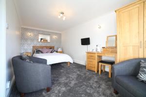 a bedroom with a bed and a desk and two chairs at Dalegarth Guesthouse Portinscale in Keswick