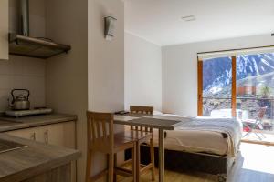 una cocina con mesa y una ventana con una montaña en Lodge El Morado, en Refugio Lo Valdés