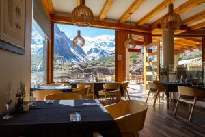 ein Restaurant mit Tischen und Stühlen und Bergblick in der Unterkunft Lodge El Morado in Refugio Lo Valdés