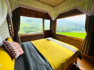 1 dormitorio con cama amarilla y ventana grande en Ginn's House, en Sa Pả