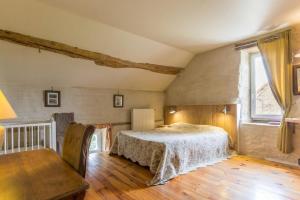 Schlafzimmer mit einem Bett, einem Tisch und einem Fenster in der Unterkunft Les Alouettes 