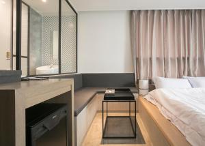 a bedroom with a bed and a desk and a sink at Hotel Wolmido in Incheon