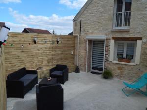 a backyard with a wooden privacy fence and chairs at L'étonnante in Margny-lès-Compiègne