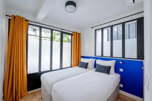 um quarto com 2 camas e janelas grandes em Magnifique appartement 2BR/4P - Marais/Bastille em Paris