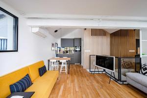 uma sala de estar com um sofá e uma mesa em Magnifique appartement 2BR/4P - Marais/Bastille em Paris