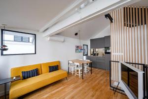 uma sala de estar com um sofá amarelo e uma mesa em Magnifique appartement 2BR/4P - Marais/Bastille em Paris