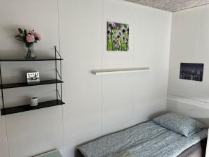 1 dormitorio con 1 cama y un jarrón de flores en Pavillon Greve, en Greve