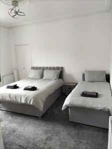 Maze Great Escape في آير: سريرين في غرفة نوم بجدران بيضاء