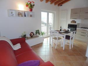 a living room with a red couch and a table at Cà Del Polsèt in Brenzone sul Garda +20 photos