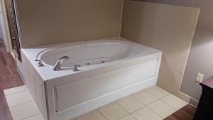 a white tub with a faucet in a bathroom at Red Roof Inn & Suites Midland in Midland