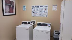 a laundry room with two machines and posters on the wall at Red Roof Inn & Suites Midland in Midland +9 photos