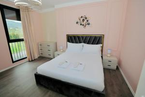 um quarto com uma grande cama branca e uma janela em Miku Apartment - Unique 3 Bedroom At Olympic Residence em Tirana