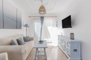 un salon blanc avec un canapé et une table dans l'établissement Home2Book Puerto Rico Pool & Sun Apartment, à Puerto Rico