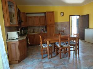 騰匹歐保沙尼亞的住宿－Casa Antonia，厨房配有木制橱柜和桌椅