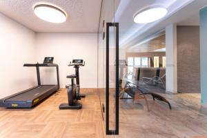 un gimnasio con cinta de correr y elípticas en una habitación en Hotel Traunfall, en Viecht