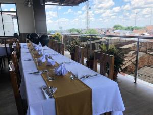 een lange tafel in een restaurant met uitzicht bij Studio 69 Aparthotel in Iquitos