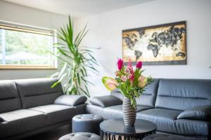 una sala de estar con sofá y un jarrón con flores sobre una mesa en Botel Racek en Praga