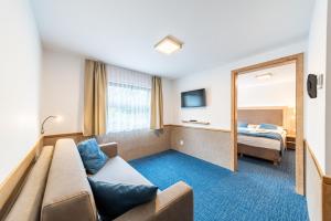 a hotel room with a couch and a mirror at Botel Racek in Prague