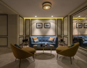 a living room with a blue couch and two chairs at 10 Karakoy Istanbul in Istanbul