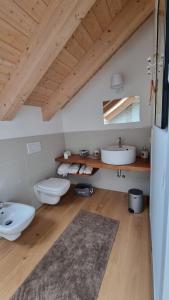 baño con 2 aseos y lavamanos en Casa delle Orchidee, en Feltre