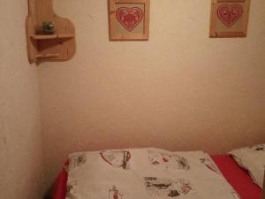 1 cama en una habitación con 2 corazones en la pared en Appartement Valloire, 1 pièce, 4 personnes - FR-1-263-485, en Valloire