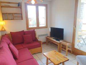 a living room with a red couch and a tv at Appartement Peisey-Vallandry, 3 pièces, 7 personnes - FR-1-411-166 in Landry
