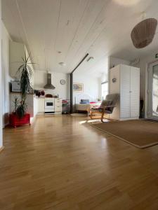 a large living room with wooden floors and a kitchen at Guest House Svetlana in Hella