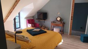 ein Schlafzimmer mit einem Bett mit einer gelben Decke in der Unterkunft Ker Anahid - L'Atelier in Pleslin-Trigavou