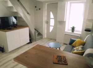 a living room with a couch and a table at Une pause au vert'gnate in Le Breuil-sur-Couze